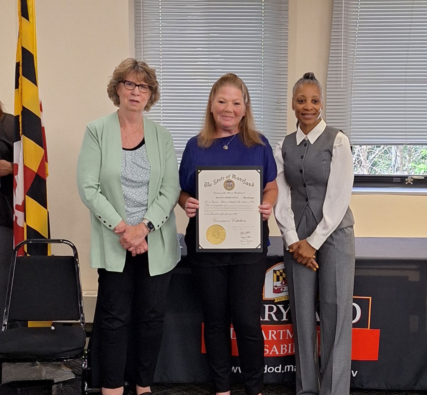 Melissa in holding an award certificate with 